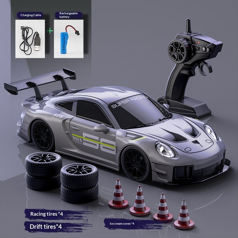 Grey RC drift car set with remote control, two tyre sets, cones and charging accessories